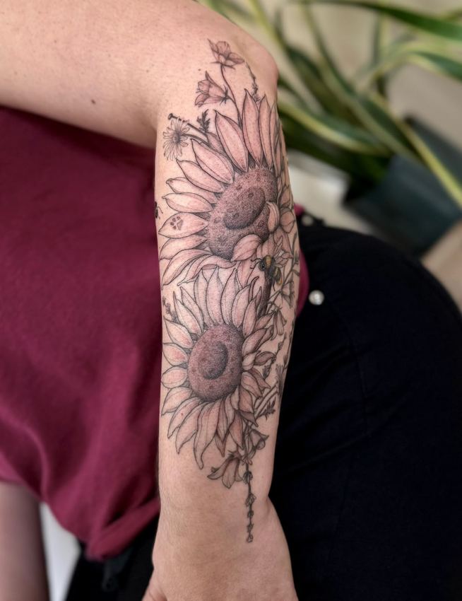 Tatuaje de girasoles en blackwork con sombreado suave, en el brazo