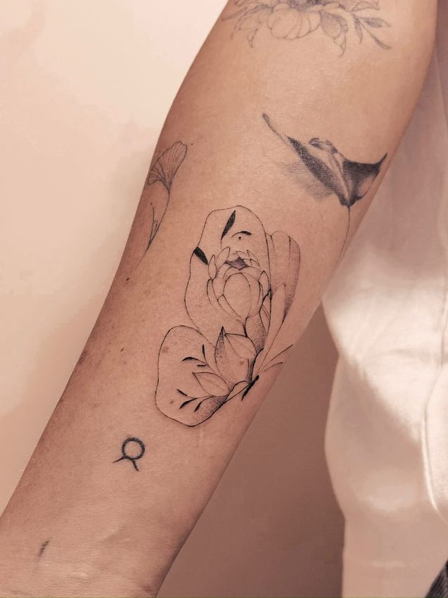 Tatuaje fine line de flores y una golondrina, en el antebrazo