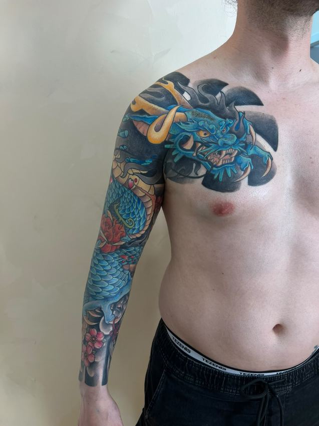 Manga completa de tatuaje japonés a color con un dragón azul en el pecho y una carpa koi en el brazo