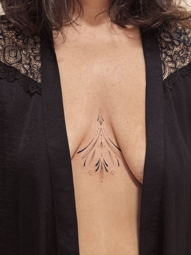 Tatuaje ornamental fine line simétrico en el esternón