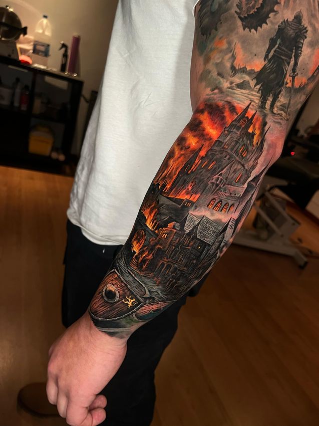 Manga completa de tatuaje realista a color con una ciudad en llamas y una figura encapuchada